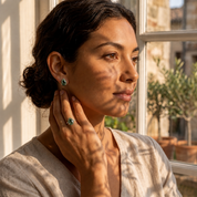Woman wearing natural moss agate teardrop stud earrings with matching gemstone ring