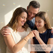 Mother receiving a minimalist custom birthstone bracelet from her family, personalized family bracelet with delicate gemstones, meaningful Mother’s Day gift jewelry for mom.