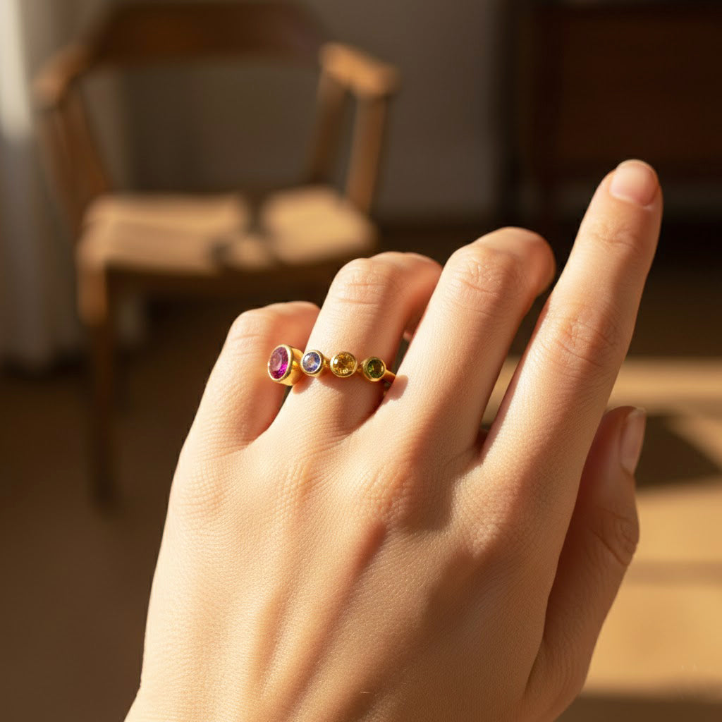 Adjustable custom birthstone ring for mom of three with bezel-set gemstones including one large 5mm stone representing mom and three smaller 3mm stones for each child, shown on a model’s hand. Personalized family ring crafted in gold vermeil, ideal for everyday wear. A thoughtful Mother’s Day gift, birthday gift, or Christmas gift that celebrates motherhood, family connections, and meaningful jewelry for moms of multiple kids.