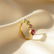 Elegant custom birthstone ring for moms of three displayed with soft lighting on champagne satin, showcasing its adjustable gold band, bezel-set 5mm main stone, and three personalized 3mm birthstones for each child. A meaningful keepsake gift for Mother’s Day, new mom celebrations, birthdays, and Christmas. Crafted with high-quality materials, this ring symbolizes family love and personalized jewelry for everyday wear.