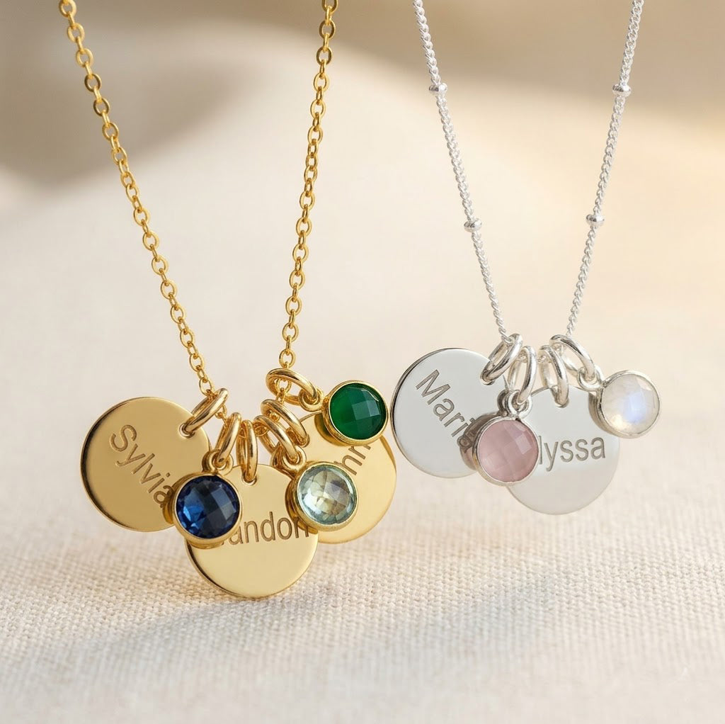 Gold filled cable chain necklace with three engraved disks and kyanite, sky blue quartz and green onyx birthstones. Sterling Silver necklace with satellite chain and two engraved name disks with pink chalcedony and moonstone birthstones. 