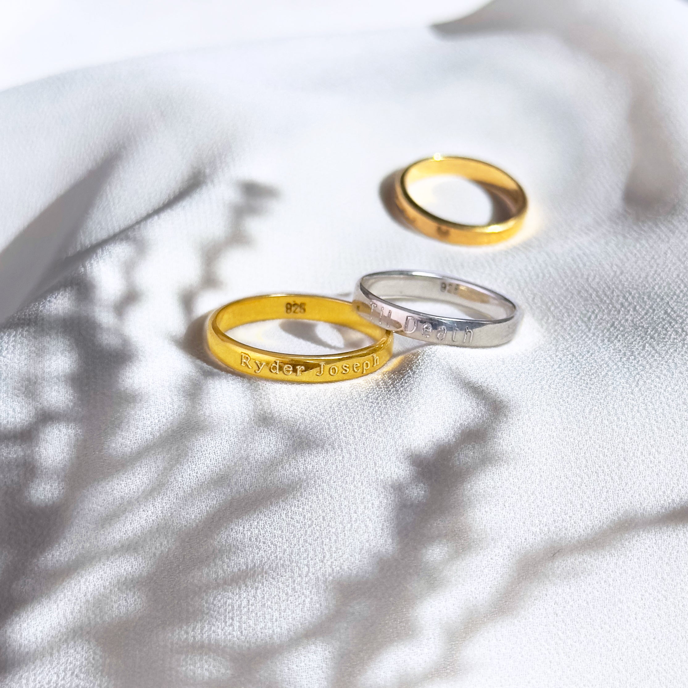 Two gold plated rings with names and a silver ring engraved with til death. Custom Engraved, Name Engraving, Date Engraving, Coordinates Engraving, Initials, Short Quote, Secret Message, Love Note, Roman Numerals, Forever, Always, Promise ring, Soulmate, Best Friends, Family Bond, Anniversary Gift, Birthday Gift, Graduation Gift, Wedding Band, Couple Ring, Memorial Ring, valentine's day, Sentimental, Hidden Message, Minimalist Design, christmas, gift for husband, gift for wife