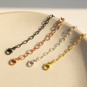 Necklace extender chains in sterling silver, gold filled, rose gold, and oxidized blackened silver displayed on a white plate. Adjustable chain extender adds 1–6 inches to necklaces or bracelets, making it perfect for layering jewelry or customizing fit. Popular jewelry accessory gift for women who love delicate, minimalist necklaces.