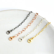 Necklace extender chains in sterling silver, gold filled, rose gold, and oxidized blackened silver displayed on a white plate. Adjustable chain extender adds 1–6 inches to necklaces or bracelets, making it perfect for layering jewelry or customizing fit. Popular jewelry accessory gift for women who love delicate, minimalist necklaces.