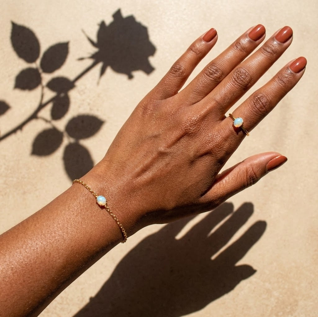 Dainty opalite ring styled with matching minimalist jewelry on a woman's hand