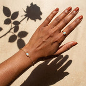 Dainty opalite ring styled with matching minimalist jewelry on a woman's hand