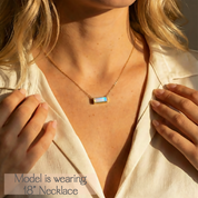 Woman wearing a horizontal Opalite gemstone bar necklace with hidden message engraved in yellow gold as a minimalist everyday necklace.