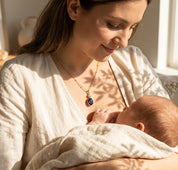 Dainty gold birthstone necklace with one large oval gemstone and one small round charm, a thoughtful just because gift for her shown on a new mom
