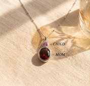 Two stone birthstone necklace with a larger birthstone for mom and a smaller birthstone for child, designed as a sentimental new mom necklace.