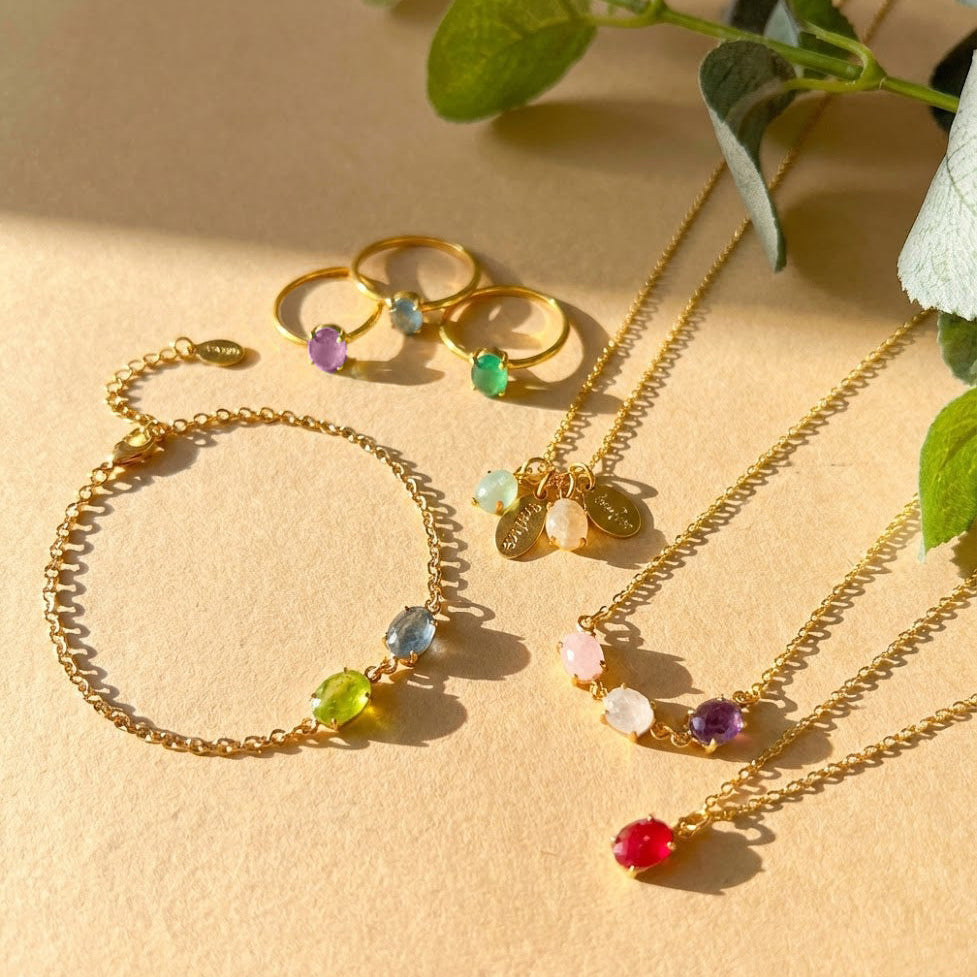 Personalized birthstone jewelry collection featuring oval cabochon gemstone necklace, bracelet, and stacking rings displayed on a warm neutral background. Custom family birthstone designs crafted in gold vermeil or gold filled, showcasing colorful natural gemstones that represent children, loved ones, or meaningful milestones. Elegant minimalist jewelry designed as thoughtful gifts for mom, grandma, wife, or daughter, perfect for Mother’s Day, birthdays, anniversaries, new mom gifts, and everyday sentimenta