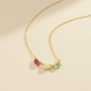 Elegant horizontal oval birthstone necklace displayed on ivory background, featuring bezel-set oval gemstones including peridot, emerald quartz, moonstone, and blue topaz. A custom multi-stone mother necklace ideal for engraving a child’s name or birthdate on the back for sentimental meaning. Perfect Christmas or Mother’s Day gift for moms, grandmas, or new mothers who want personalized family jewelry made in high-quality gold, rose gold, or silver.