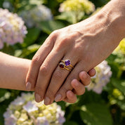 Purple gemstone stacking ring set worn outdoors on a woman’s hand in natural sunlight