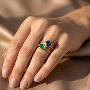Woman wearing green and blue gemstone stacking rings in yellow gold vermeil in warm natural light