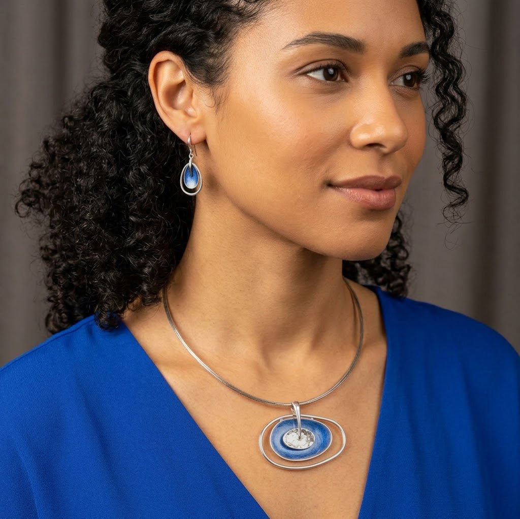 Woman wearing blue double oval boho statement necklace with matching earrings

