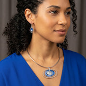 Woman wearing blue double oval boho statement necklace with matching earrings

