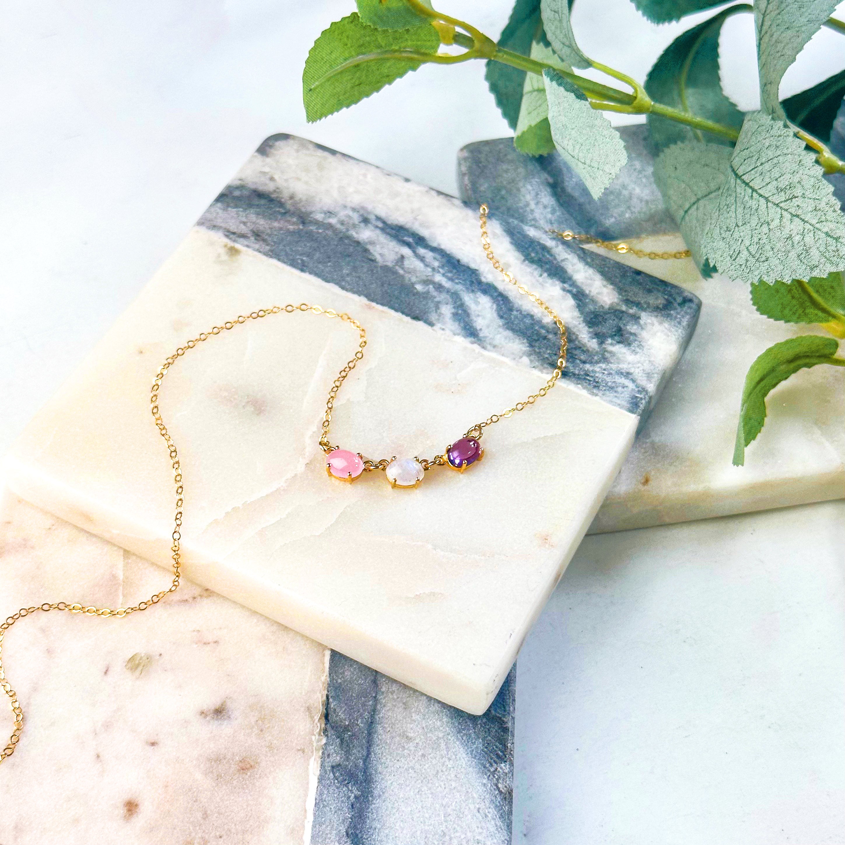 Gold filled oval prong set cabochon necklace with pink chalcedony, moonstone and purple amethyst gemstones. 