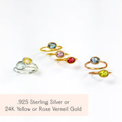 Collection of oval birthstone rings in .925 sterling silver and 24K yellow or rose vermeil gold; bezel-set hydro gems shown in Aquamarine (March), Pink Tourmaline (October), Ruby (July), Peridot (August), Citrine (November). Minimalist stacking rings, gift-ready.