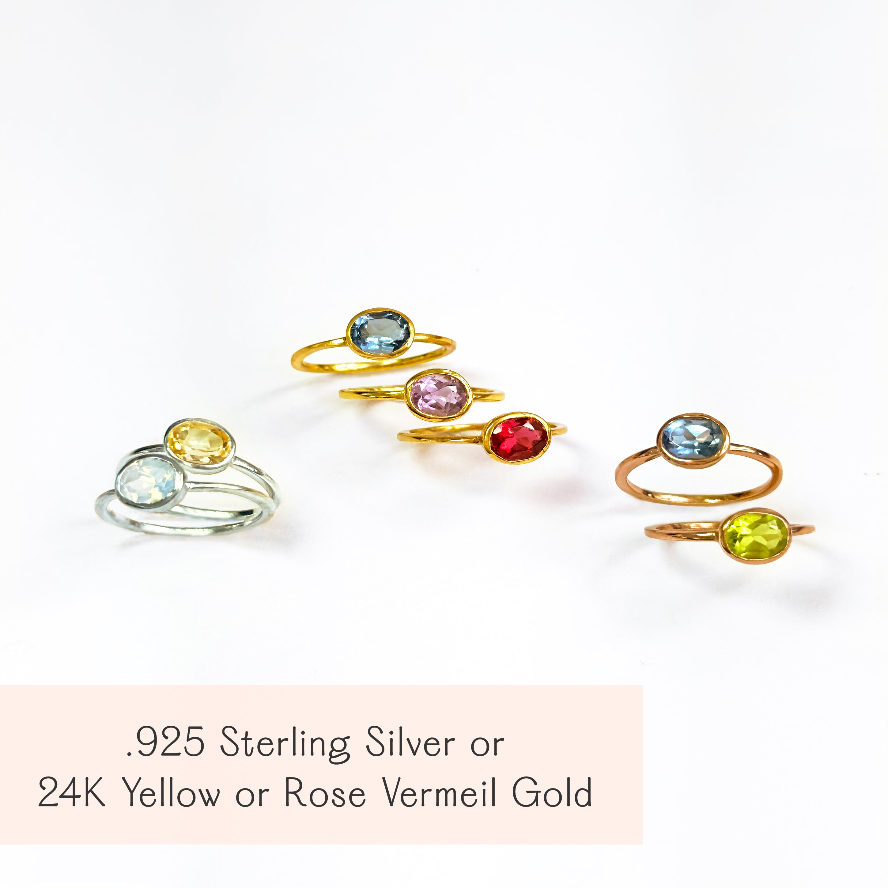 Collection of oval birthstone rings in .925 sterling silver and 24K yellow or rose vermeil gold; bezel-set hydro gems shown in Aquamarine (March), Pink Tourmaline (October), Ruby (July), Peridot (August), Citrine (November). Minimalist stacking rings, gift-ready.