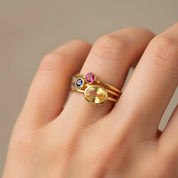 Custom mothers ring set worn on hand, stackable birthstone rings with an oval gemstone for mom and small round stones for kids, dainty minimalist family birthstone ring set in gold vermeil, personalized jewelry gift for mom of two or mom of three, choose February amethyst, March aquamarine, and April diamond/clear stone by month, everyday stacking ring set for Mother’s Day and birthdays