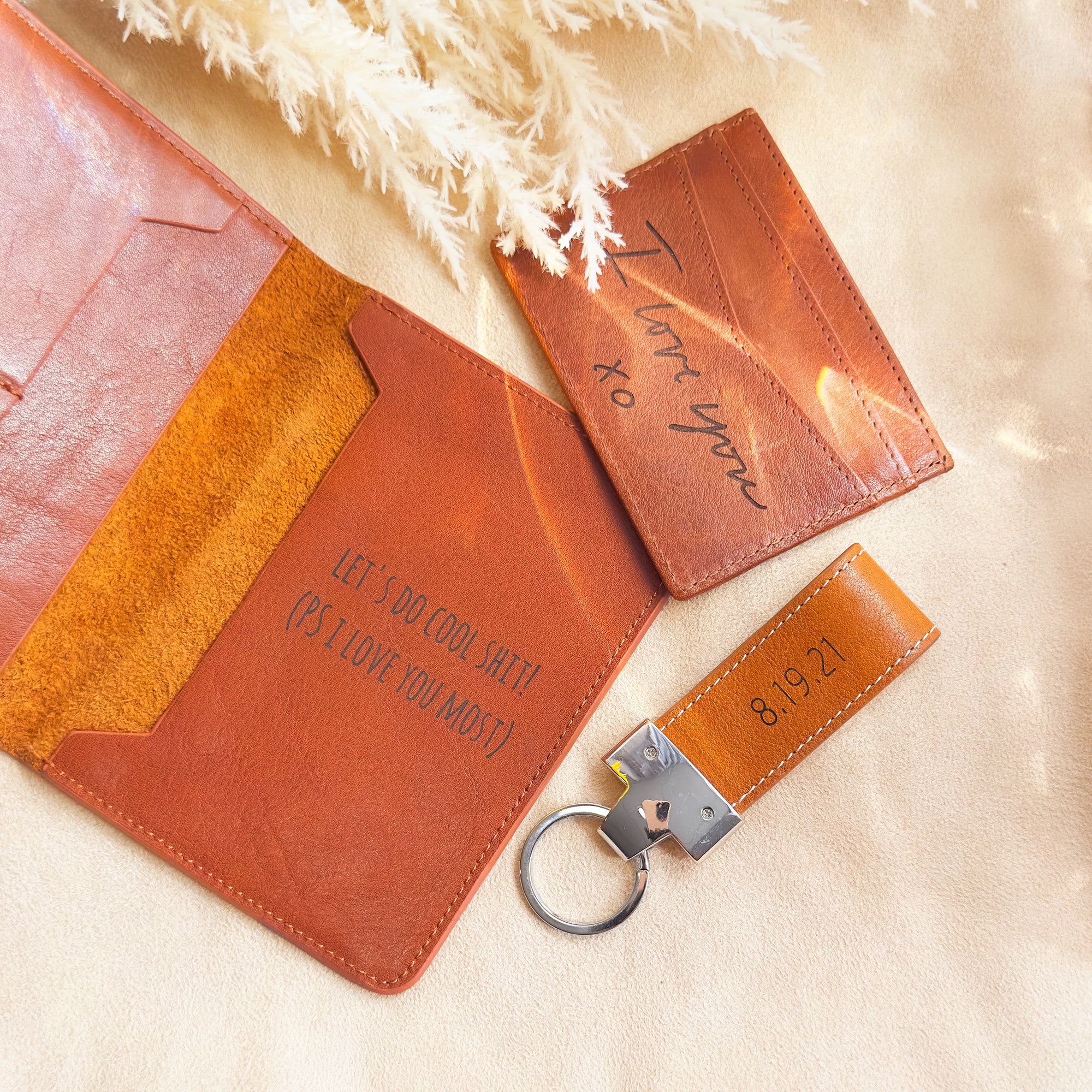 passport, card holder and large leather keychain on beige background. Full leather collection also includes several keychain styles like paddle and loop, luggage tags, passport holders, card and wallet holders, leather anniversary, jet setter, graduation gift, gift for him, gift for her, leather gift, travel accessories
