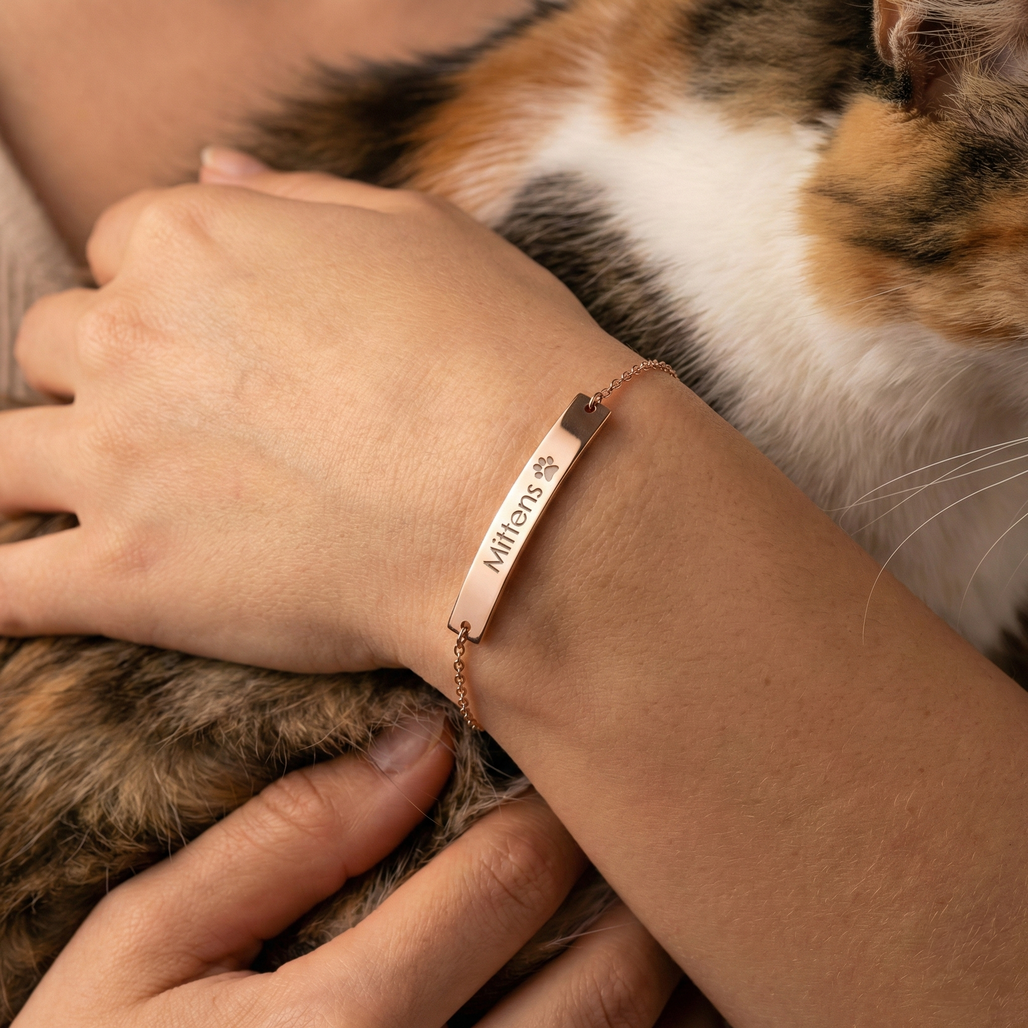 A delicate personalized bracelet featuring an engraved paw print and pet name on a minimalist bar, crafted in sterling silver as a meaningful memorial keepsake for dog or cat lovers.