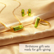 Green peridot baguette jewelry set—bar necklace, stud earrings, and statement ring in 14k gold filled with hydro gemstones—shown on champagne satin with “Birthstone gift sets ready for gift-giving.” August birthstone set; perfect birthday or bridesmaid gift.