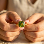 Peridot gemstone ring worn on hand with bold green color and gold band