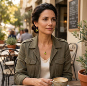 Model wearing a peridot necklace outdoors as a dainty August birthstone gift idea.