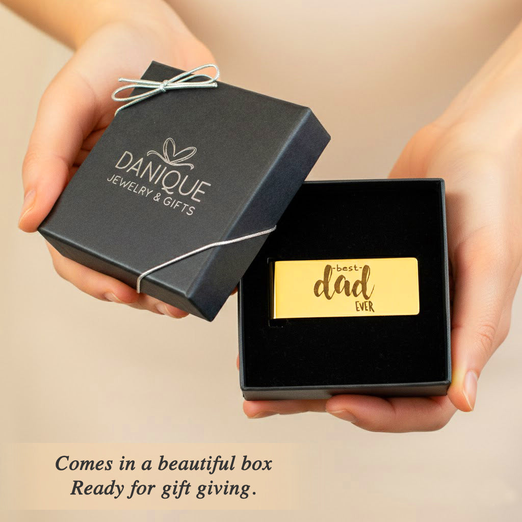 A person holding a black gift box with a gold money clip inside, showcasing elegant packaging.