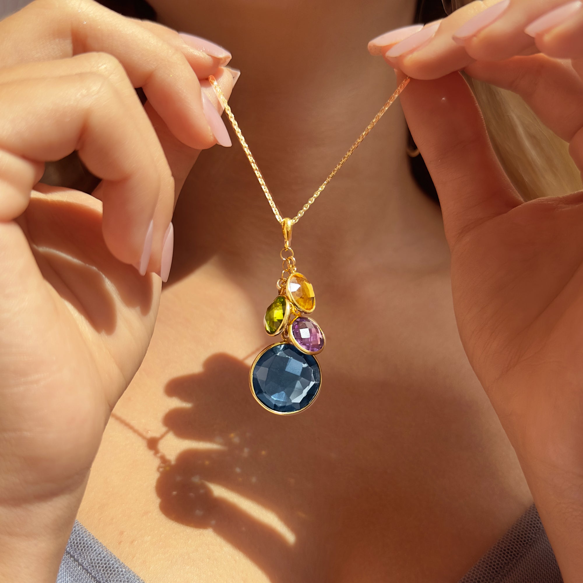 Close-up of mother’s birthstone necklace held in hands, featuring natural gemstones in bezel settings. A personalized family jewelry piece for moms or grandmas, perfect as a push present, baby shower gift, or sentimental Mother’s Day keepsake. Available in sterling silver, gold filled, rose gold filled, or oxidized silver.