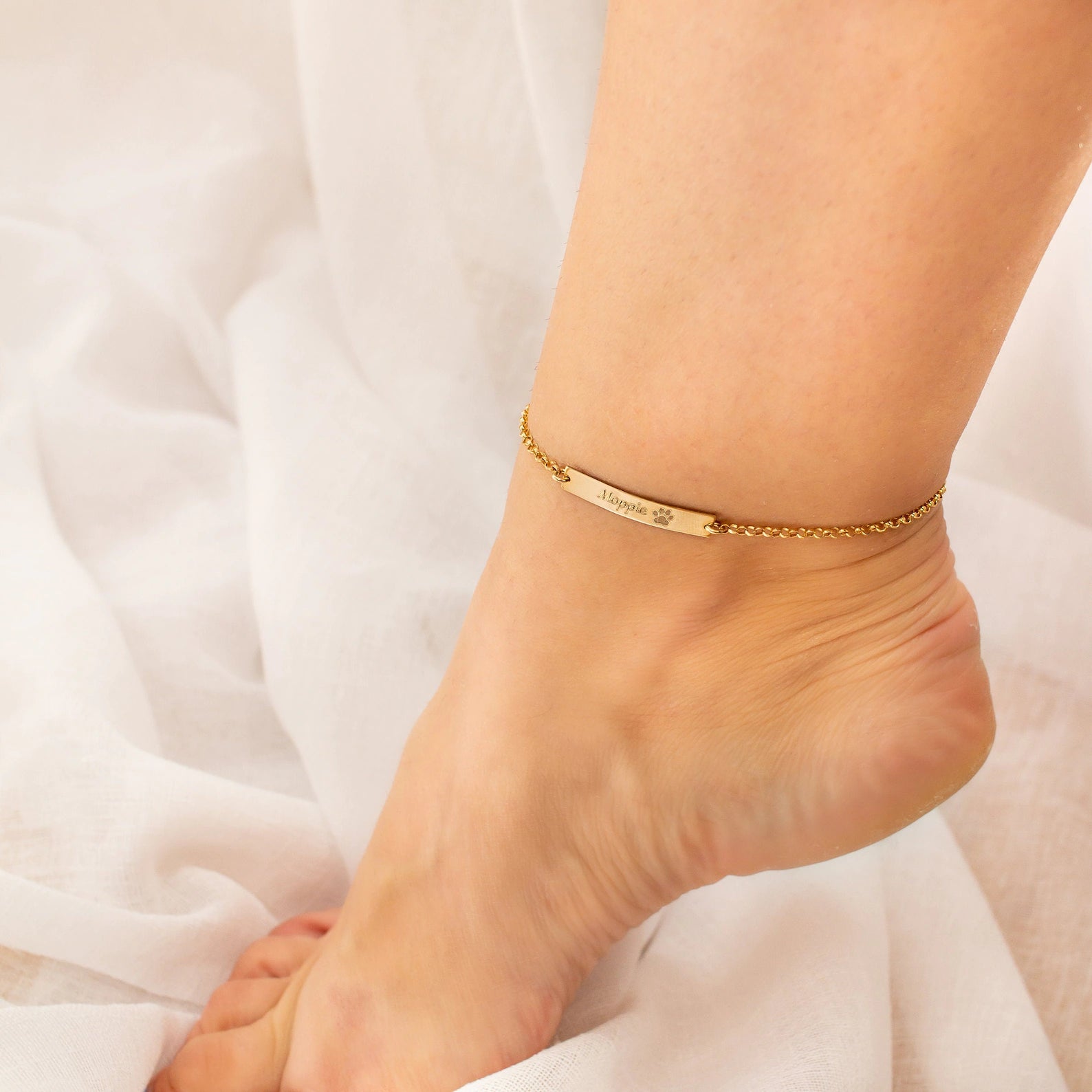 Personalized gold paw print anklet engraved with pet’s name, a unique memorial jewelry piece for dog moms and cat lovers. Customizable with paw print and message, this pet remembrance gift is handmade in sterling silver, gold filled, or rose gold filled. Ideal sympathy gift after pet loss, birthday gift for pet owners, or everyday keepsake jewelry that celebrates the love and memory of a beloved pet companion.