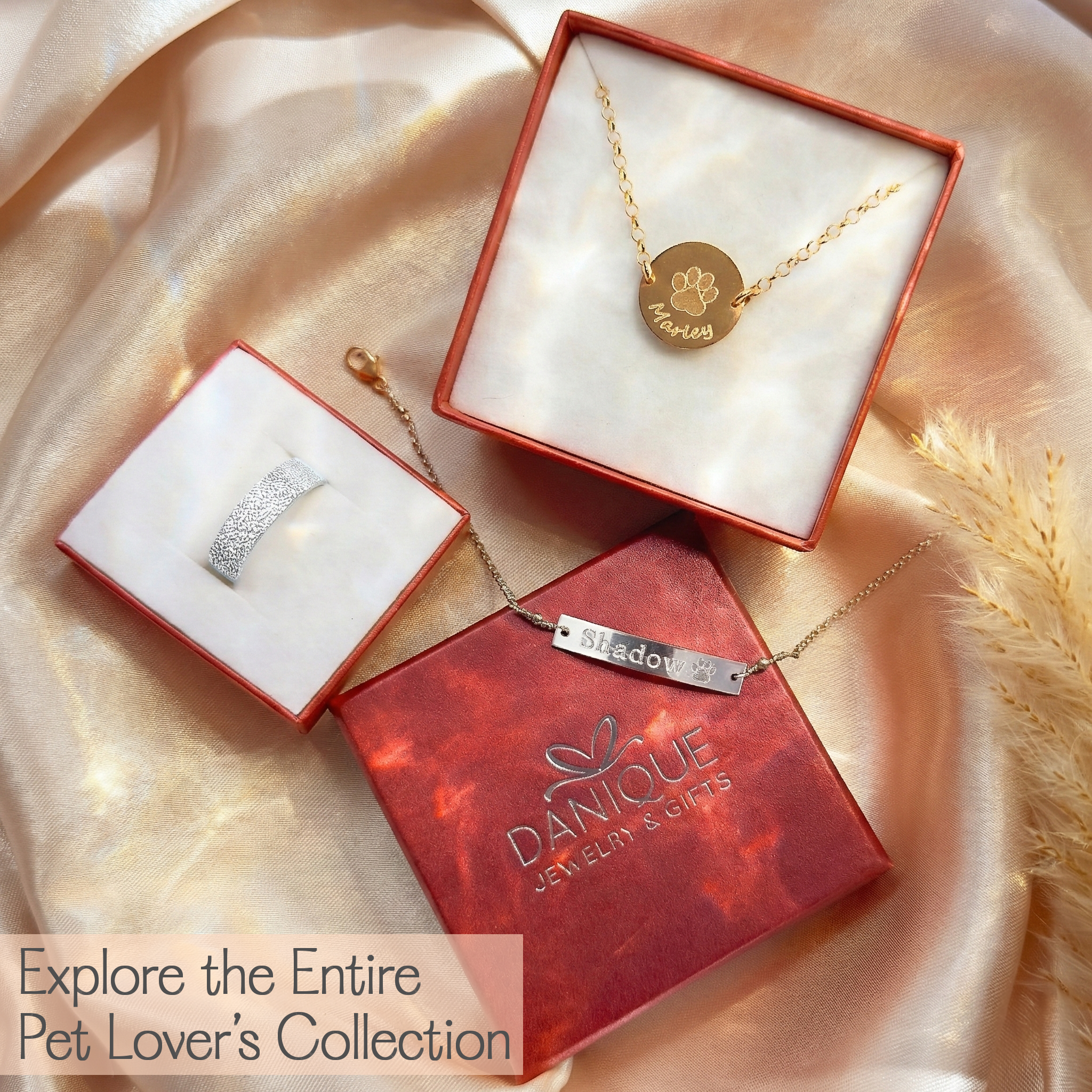 Jewelry box with necklaces and pendants on a soft fabric background, featuring the Danique Jewelry & Gifts brand.