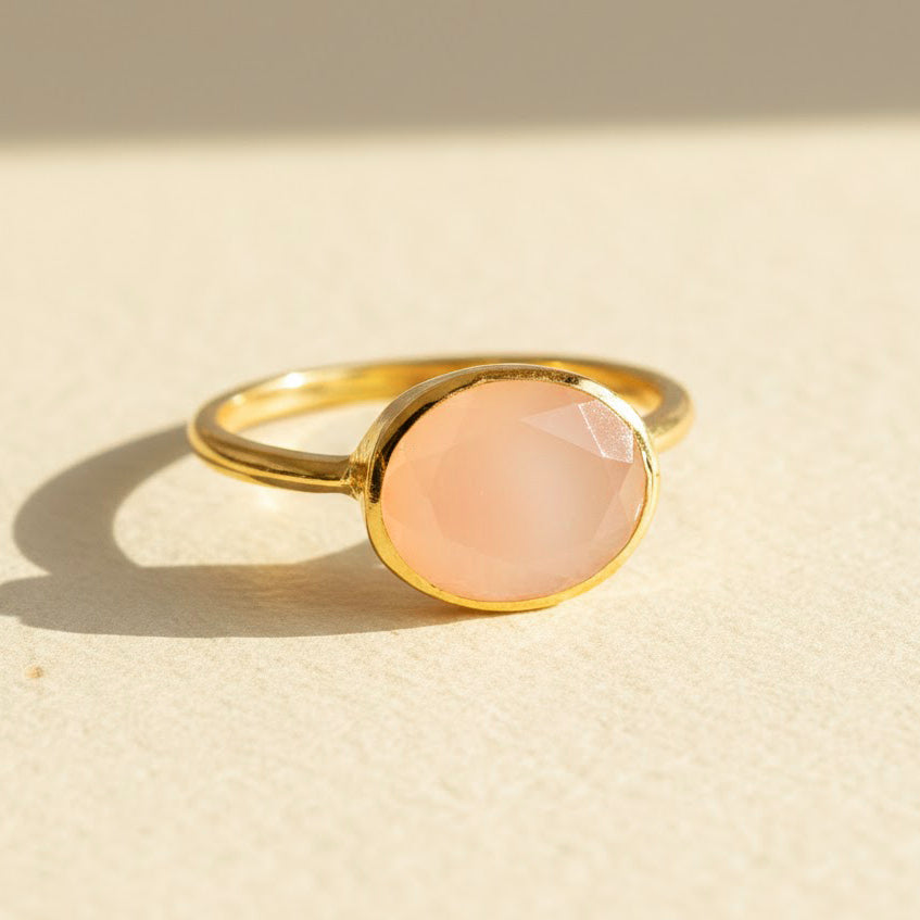 Oval pink chalcedony ring in gold bezel setting featuring soft blush gemstone, dainty oval pink stone ring for women, minimalist stacking birthstone style jewelry in yellow gold vermeil