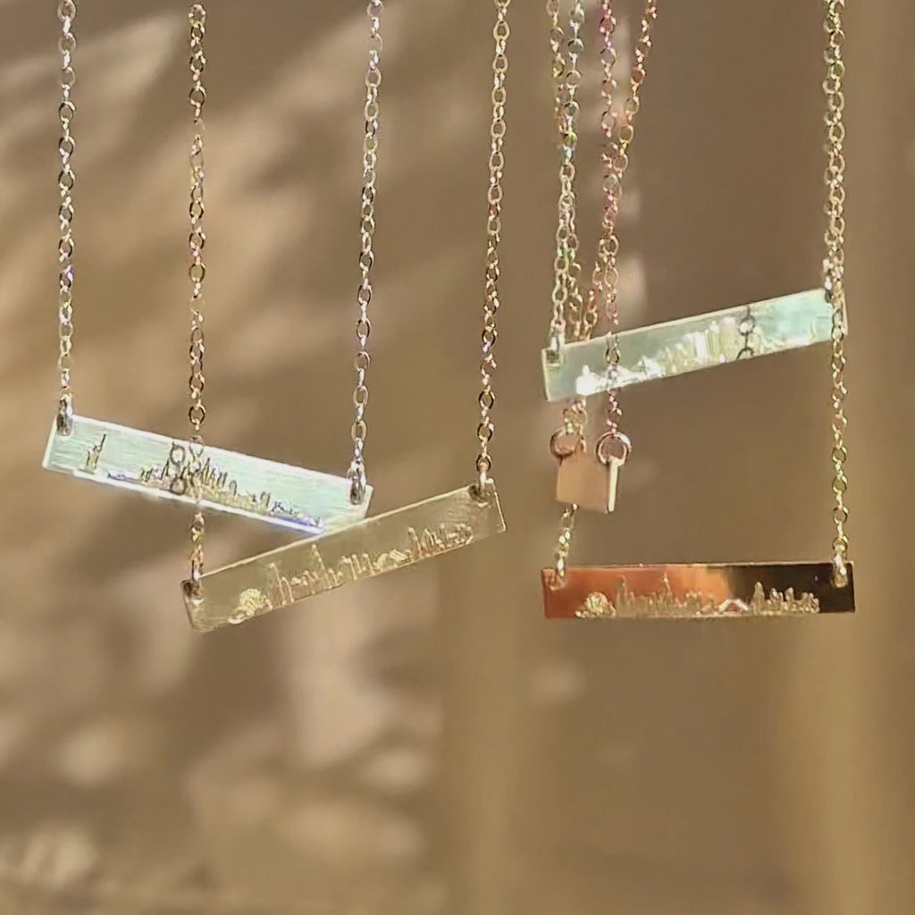Video showcasing custom skyline bar necklaces in rose gold filled, yellow gold filled, and sterling silver, featuring engraved city skyline designs on dainty bar pendants; personalized travel jewelry, meaningful city necklace gift for her, bridesmaids, graduation, or long-distance friendship.