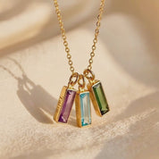 A video showcasing a Custom birthstone name bar necklace with engraved names and colorful gemstone charms on a gold chain.