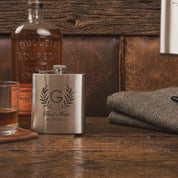 Video showcasing personalized stainless steel metal flask with custom engraving, engraved groomsmen gift for men, sleek matte finish liquor flask