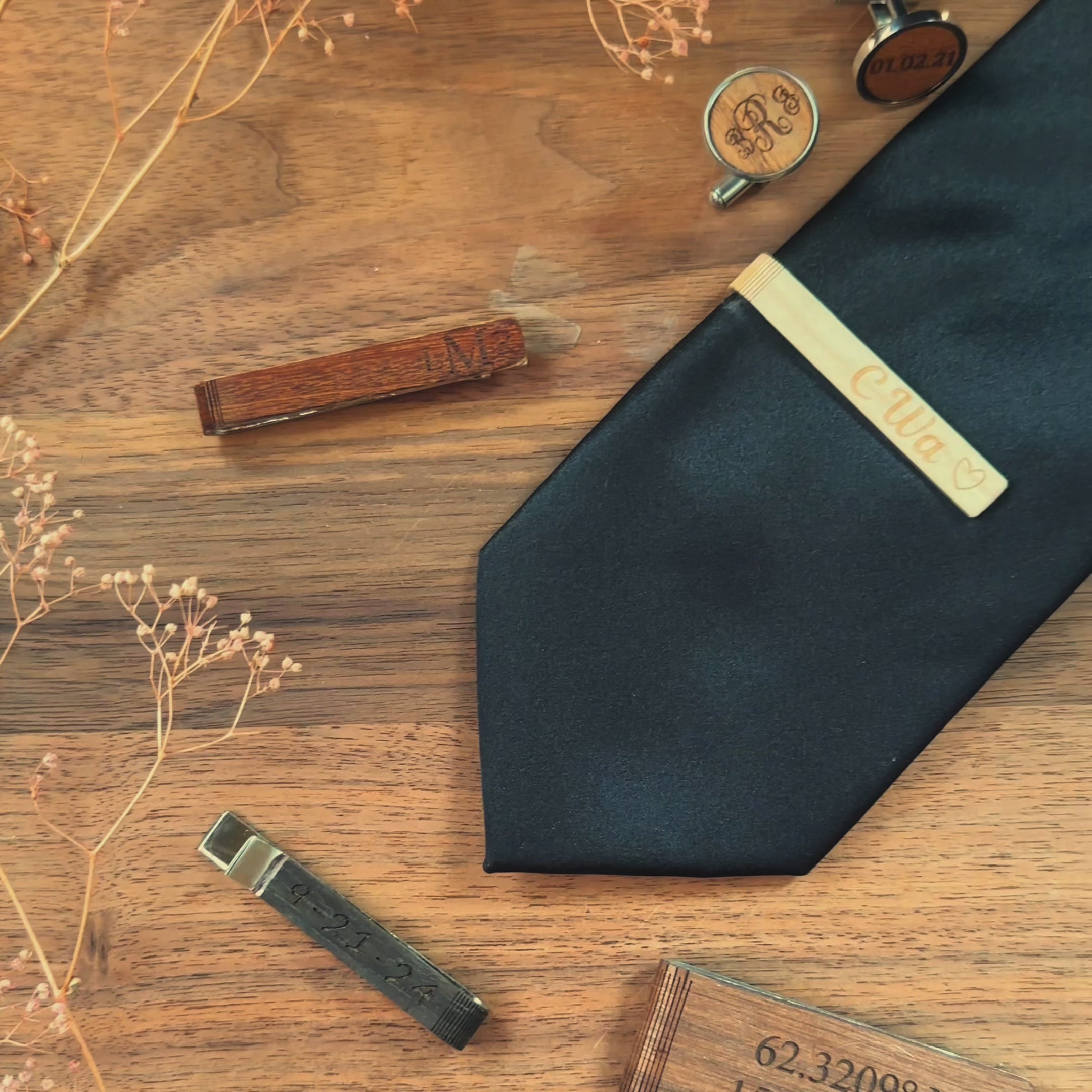 A pan over shows a variety of custom engraved rustic wooden tie clips and cuff links. A birch tie bar is turned front to back to show engravings on both sides. engraving options are monograms, photographs, names, initials, messages, and dates.  Matching cufflinks available. 6 wood finishes to choose from. Perfect for outdoor weddings.