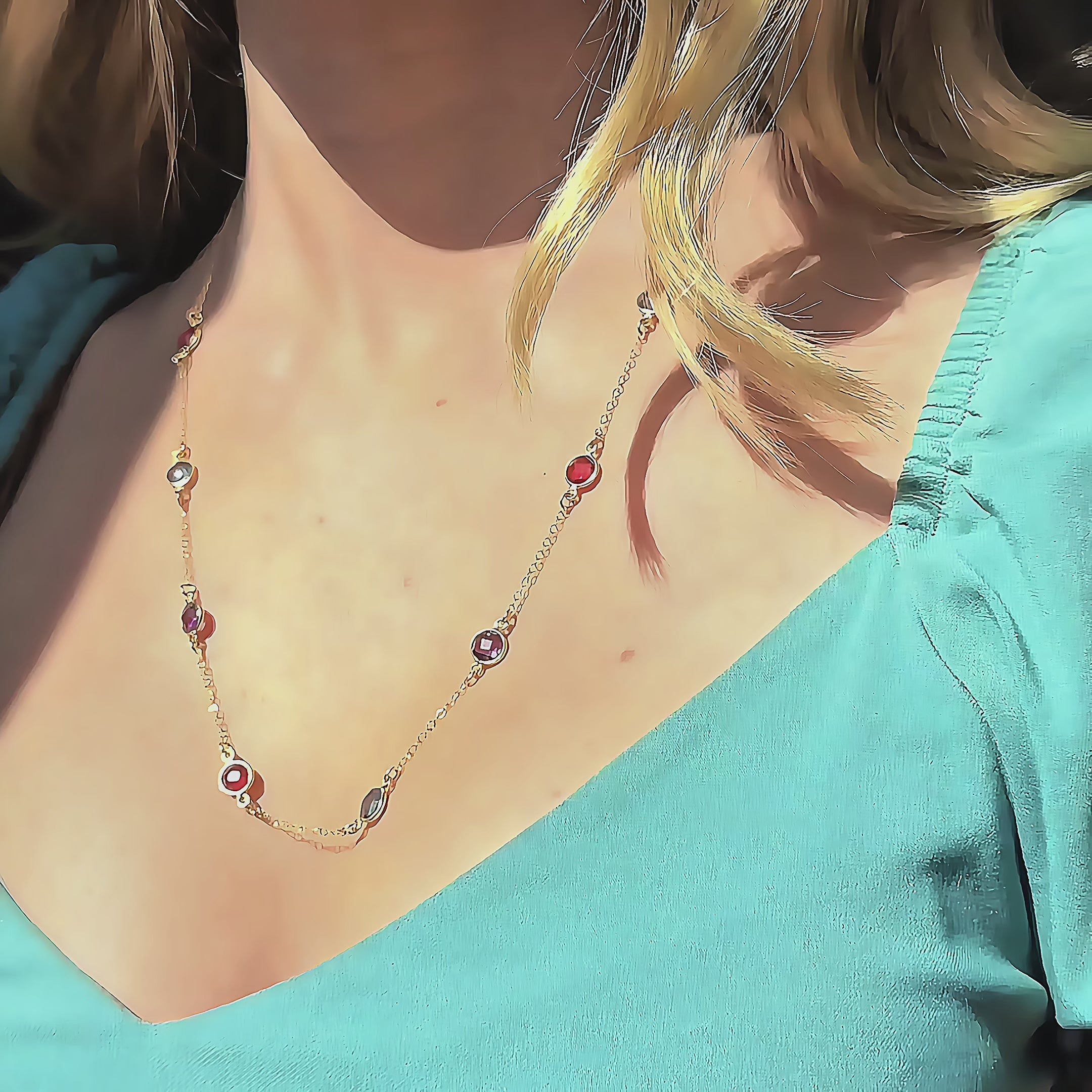 Woman wearing a Taylor Swift–inspired custom birthstone station necklace featuring a mix of June Moonstone, August Peridot, September Sapphire, and February Amethyst, sparkling across a delicate gold chain. A personalized, sentimental necklace perfect for Swifties or moms wanting a meaningful family birthstone piece, ideal for birthdays, Mother’s Day, Christmas, and elegant everyday layering.