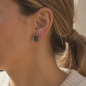 A video showcasing Natural moss agate teardrop stud earrings with faceted green gemstones in yellow gold prong settings