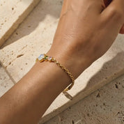 This gold vermeil family birthstone bracelet showcases one large center stone for mom and multiple smaller birthstones for children, forming a dainty, stackable piece of personalized jewelry she can wear every day.