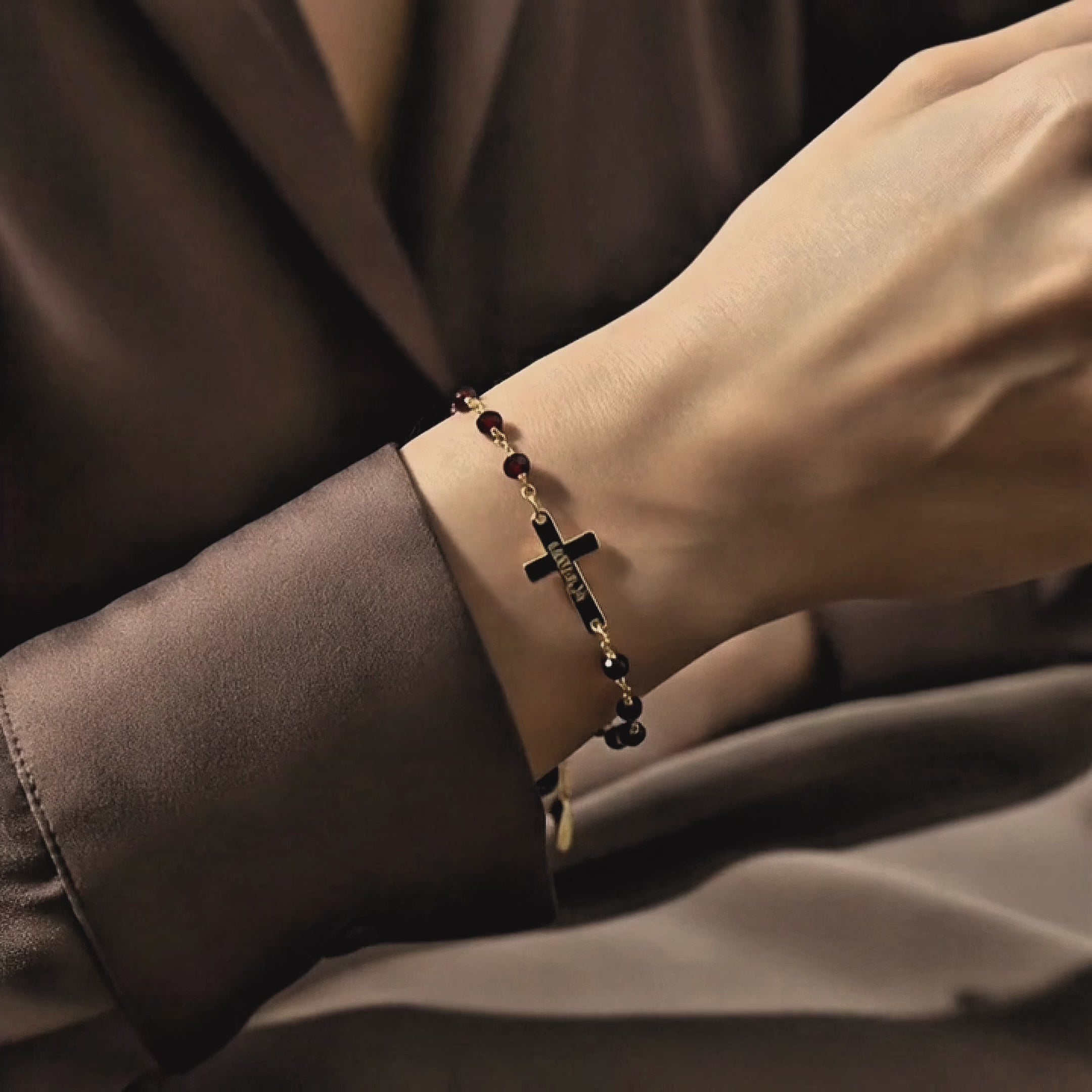 Video showcasing a dainty custom engraved cross bracelet on the wrist, featuring a slim gold bar and cross charm on a wire-wrapped natural gemstone chain; elegant personalized Christian bracelet, meaningful faith jewelry and gift for baptism, confirmation or everyday wear.