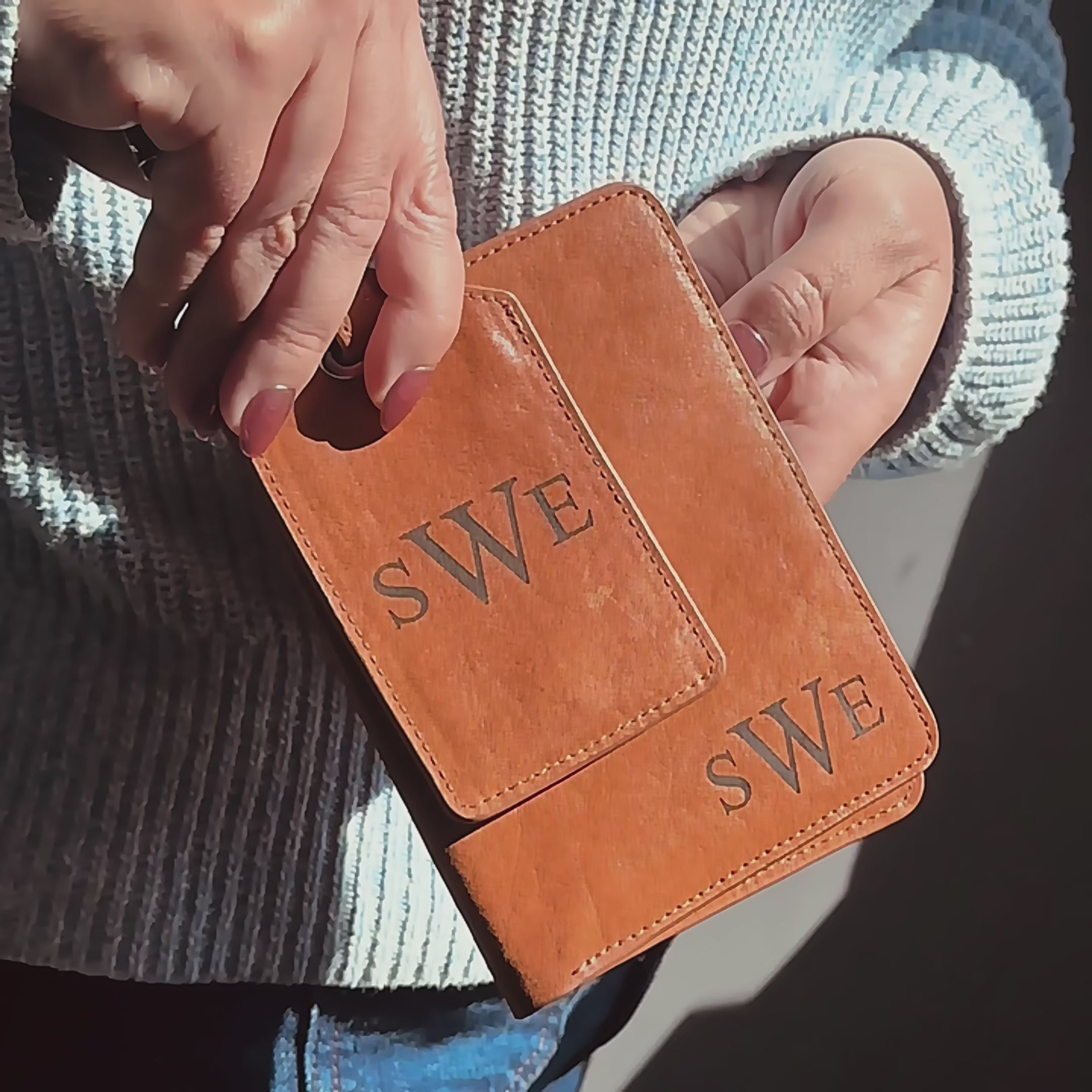 Personalized leather passport holder and luggage tag set with matching monogram initials “SWE,” laser-engraved on warm cognac natural leather. Video shows the slim passport cover and coordinating tag held in hand with finished stitching, secure strap, and polished hardware. Durable, gift-ready travel accessories for honeymoon, graduation, bridesmaids or groomsmen, and frequent flyers—customizable with initials, name, or logo; handcrafted in Massachusetts.
