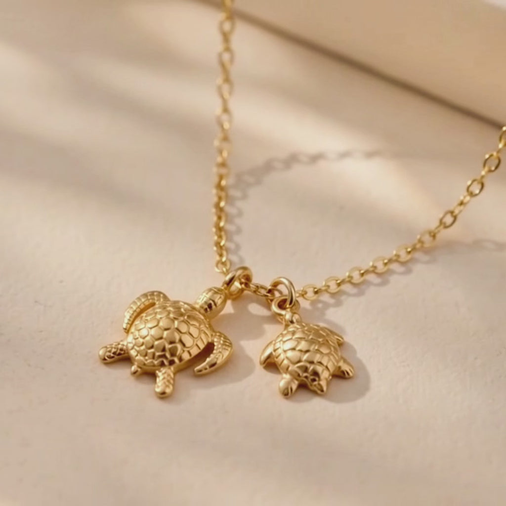 A video showcasing Mama and baby turtle necklace with two gold sea turtle charms on a delicate chain, meaningful mother and child jewelry gift.