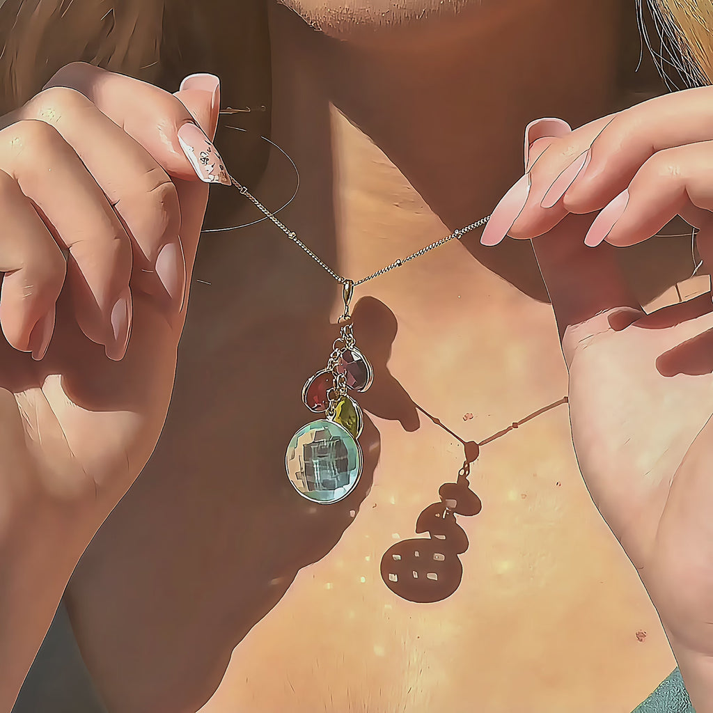 Video showcasing Gold filled cluster birthstone pendant with four bezel set gemstones in soft green, aqua and teal tones, hanging from a dainty chain on a satin beige background, customizable as a personalized family birthstone necklace and meaningful gift for mom, grandma or best friend.