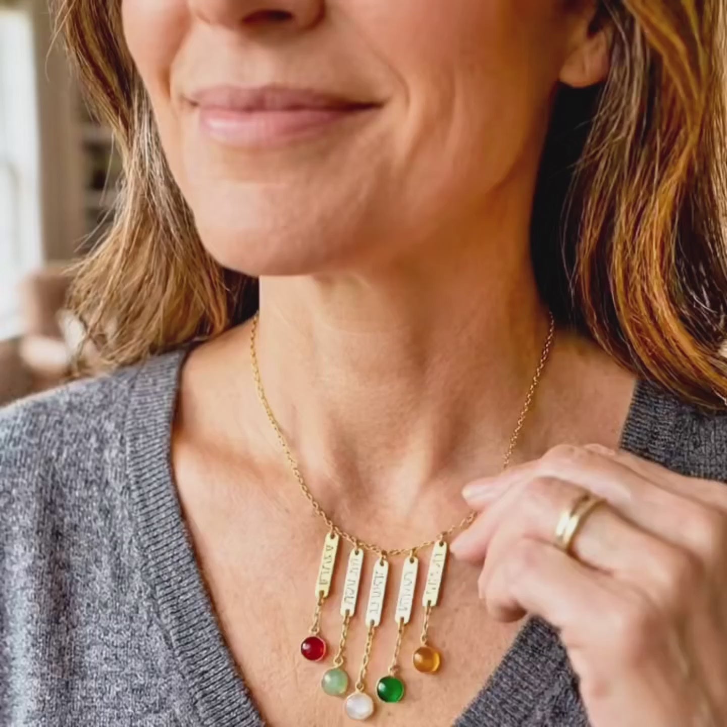 A video showcasing a Custom engraved name bar necklace with birthstone charms for mom or grandma representing her kids or grandkids