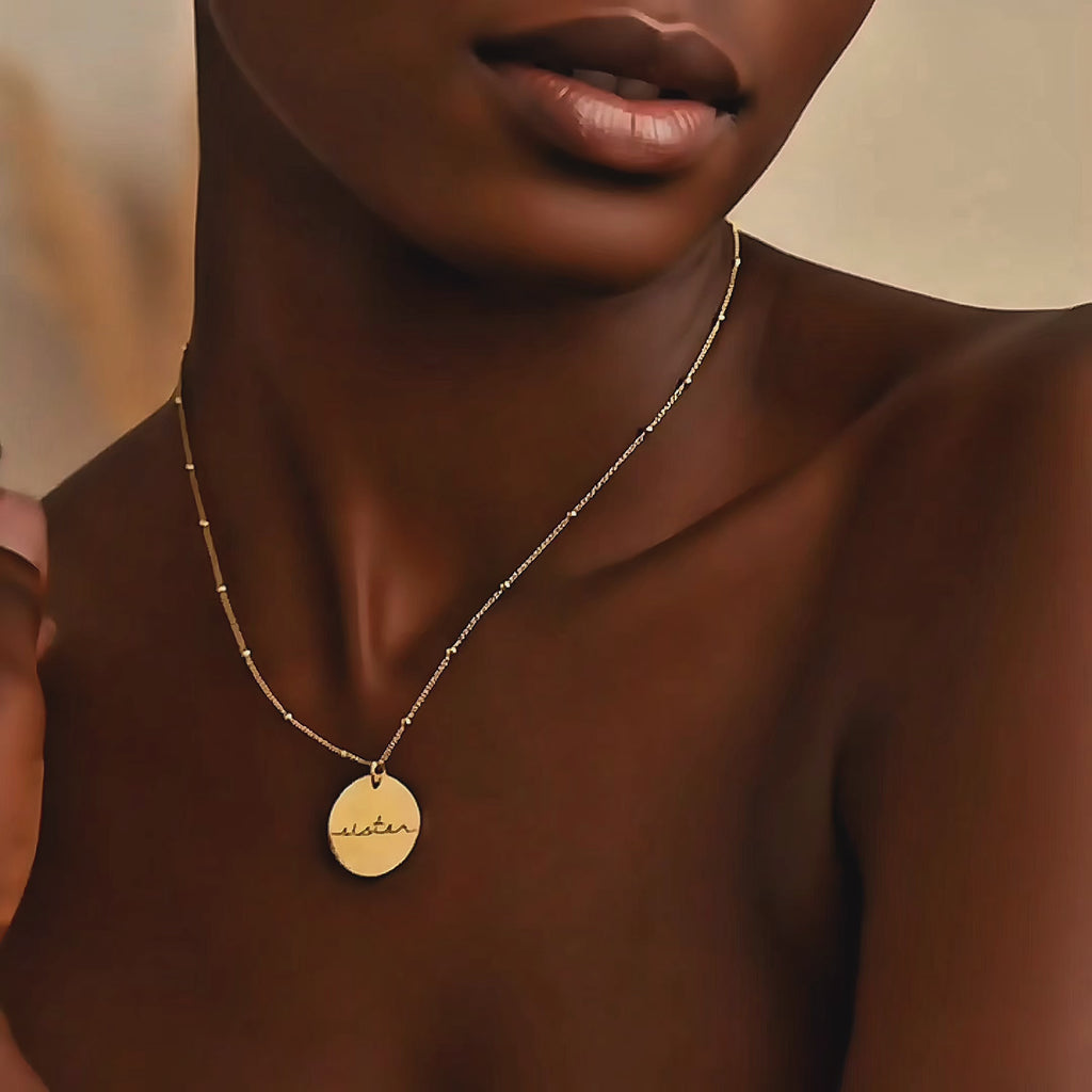 Video showcasing a 19mm round disc necklace available in yellow gold-filled, rose gold-filled, or sterling silver, featuring a custom engraved name, monogram, or short saying; minimalist personalized pendant on a delicate beaded chain, perfect for everyday wear or gifting.