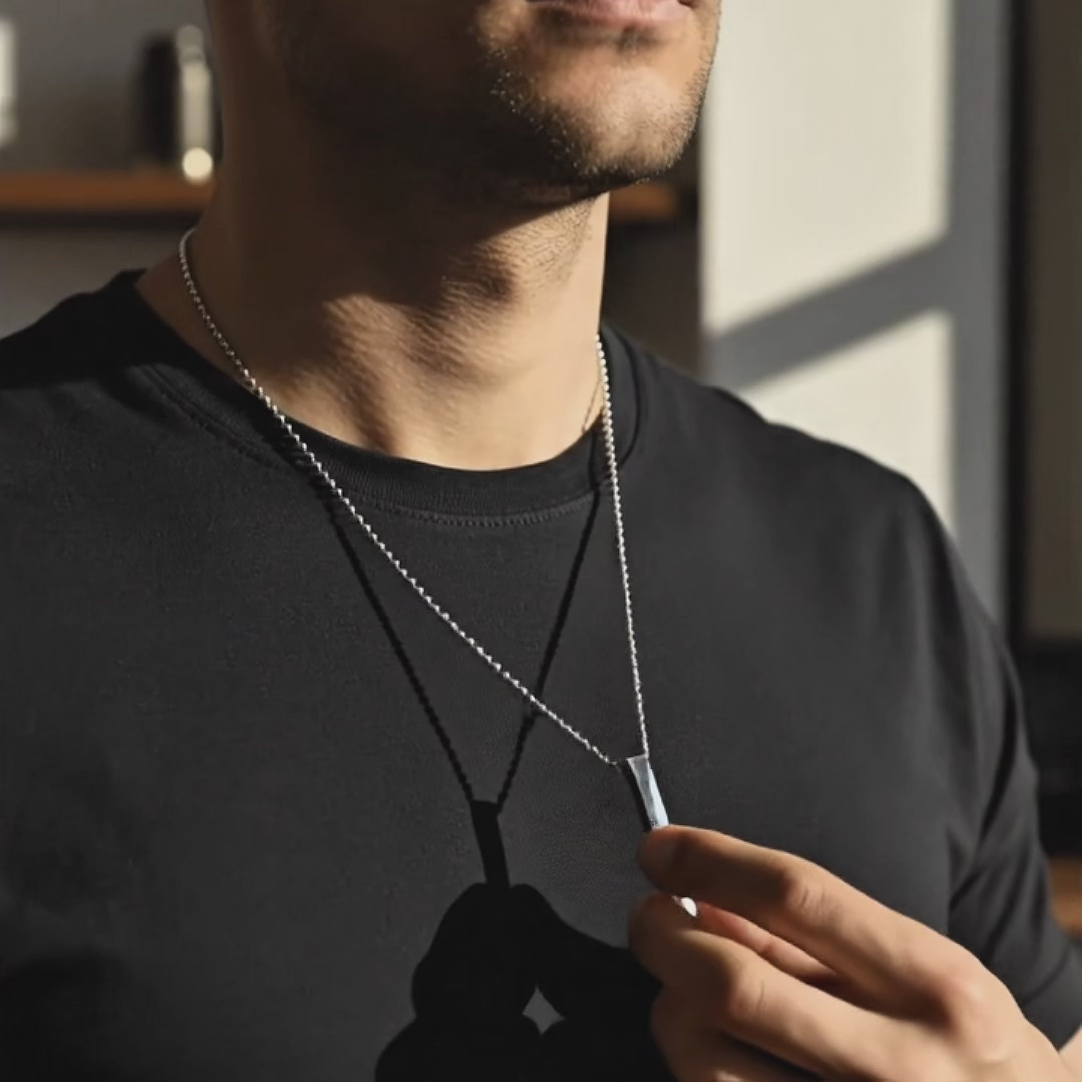 video showcasing Engraved 3D bar necklace for men in stainless steel shown up-close while being held, highlighting deep custom engraving, sleek vertical bar shape, and personalized text options like coordinates, name or Roman numerals. Masculine everyday accessory and meaningful custom gift for boyfriend, dad or husband in modern minimalist style.