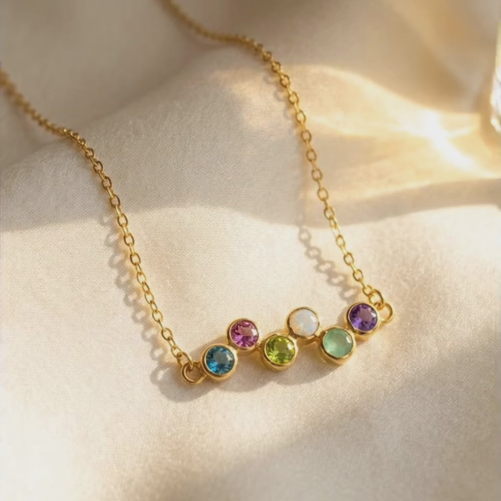 a video showcasing Zigzag birthstone necklace with colorful round gemstones on a delicate gold-filled chain, personalized with up to six stones for kids or grandkids.