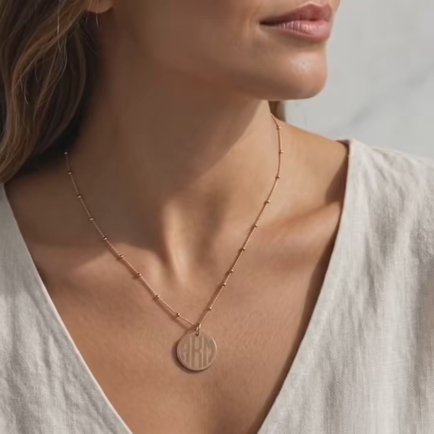 Video showcasing a 19mm round disc necklace available in yellow gold-filled, rose gold-filled, or sterling silver, featuring a custom engraved name, monogram, or short saying; minimalist personalized pendant on a delicate beaded chain, perfect for everyday wear or gifting.