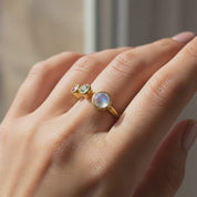 Close-up of adjustable gold birthstone ring for mom showing flexible open band design, personalized family ring featuring July ruby and August peridot, custom mother’s jewelry ideal for everyday wear and sentimental gift.